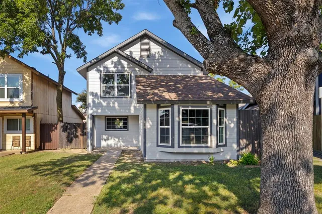 a front view of a house with a tree in a yard