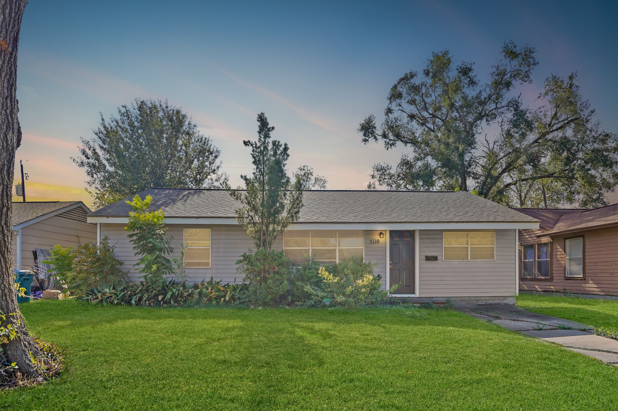 a front view of a house with a garden