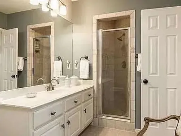 a bathroom with a double vanity sink mirror and shower