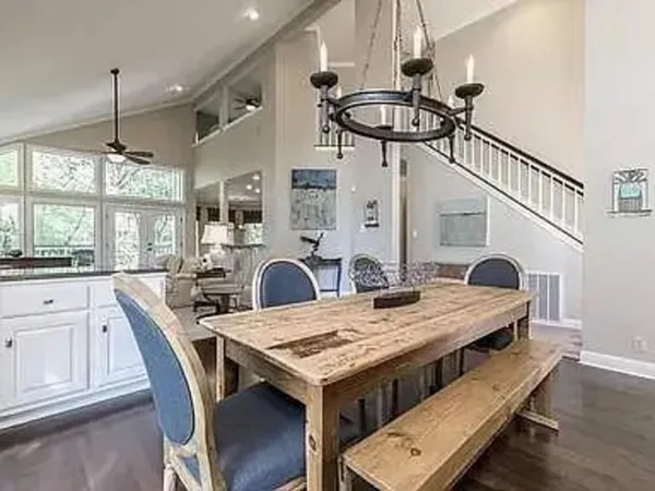 a view of a dining room and livingroom with furniture wooden floor a chandelier