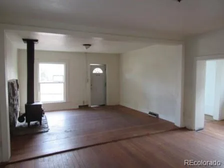 an empty room with wooden floor and a window
