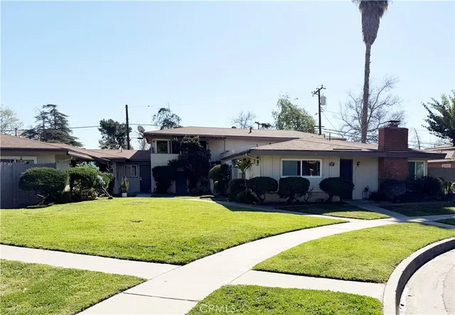 a view of a house with a backyard patio and swimming pool