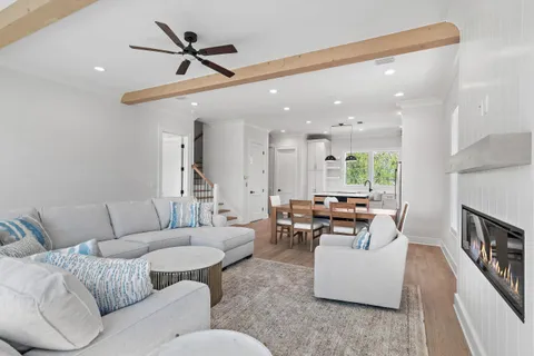 a living room with furniture kitchen view and a chandelier