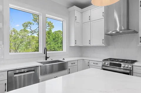 a kitchen with stainless steel appliances white cabinets and a window