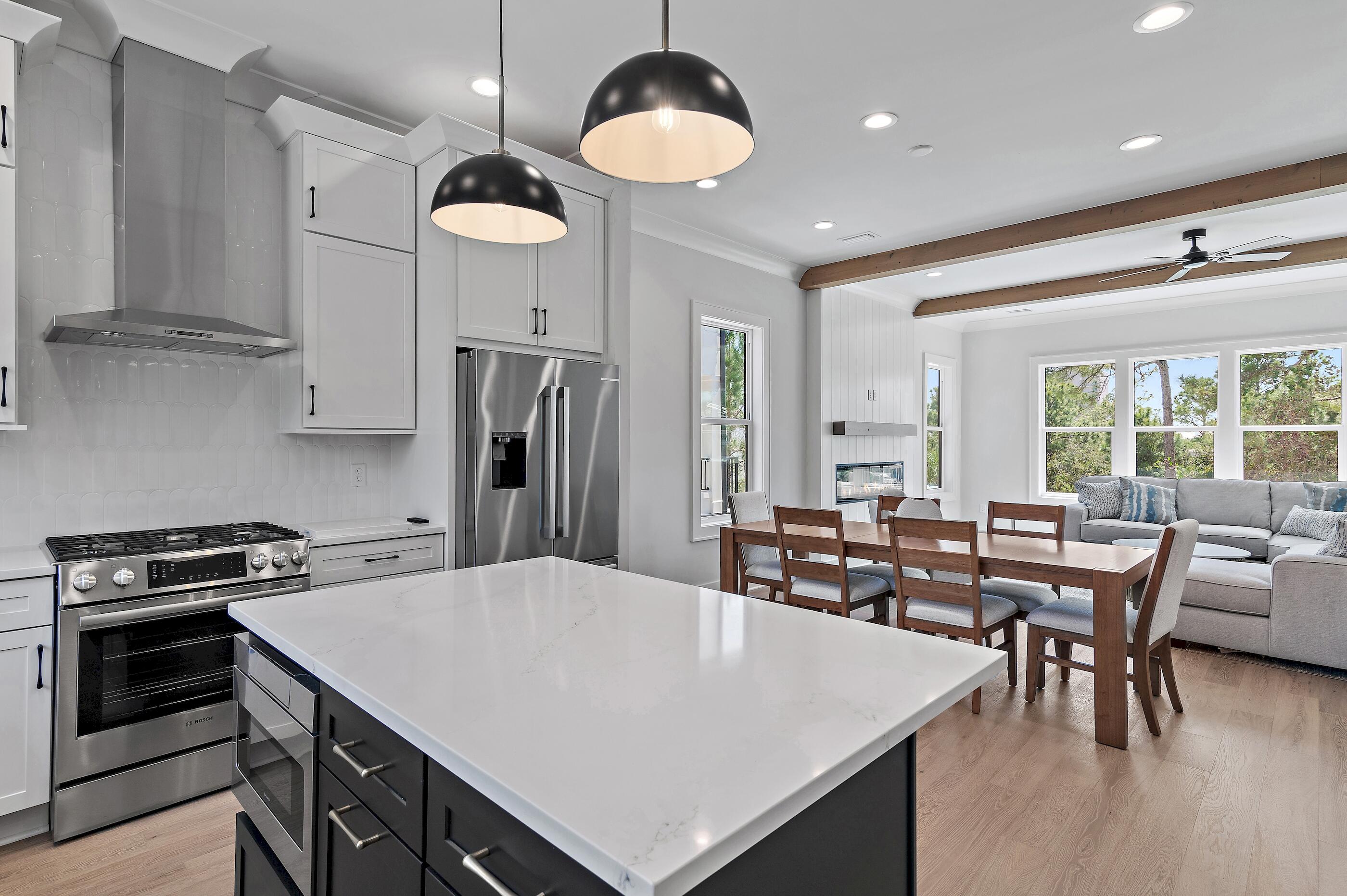 22 Henderson Place Santa Rosa Beach, FL 32459 - Photo 10 of 33 a kitchen with stainless steel appliances granite countertop a stove a refrigerator a kitchen island a dining table and chairs