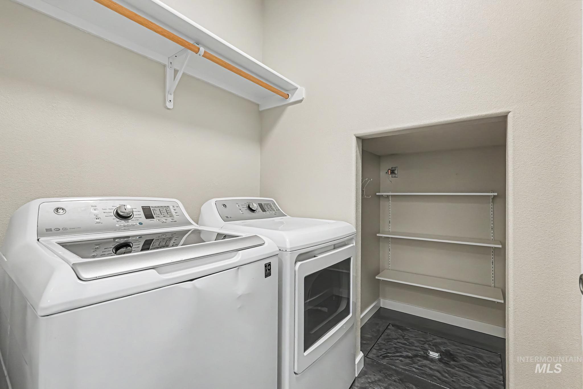 14421 West Stockwell Street Boise, ID 83713 - Photo 16 of 20 Dedicated laundry area featuring a built-in shelf with a hanging rod, an adjacent storage alcove with adjustable shelving, and dark-toned flooring