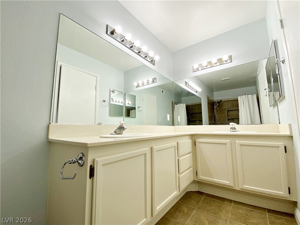 1575 West Warm Springs Road, Unit 1024 Henderson, NV 89014 - Photo 13 of 25 Dual vanities and a spacious mirror create an inviting bathroom retreat.