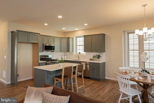 a kitchen with appliances a table and chairs in it
