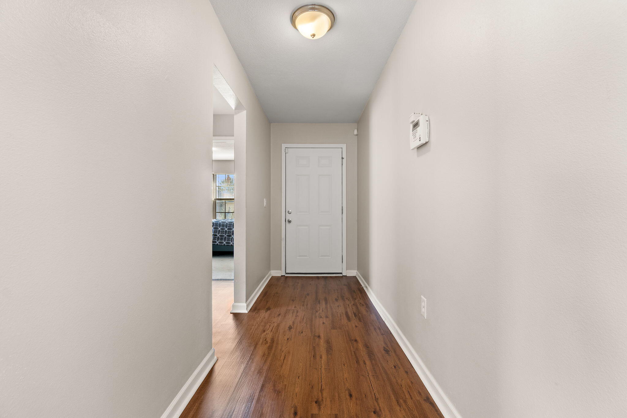 7964 Promise Creek Road Navarre, FL 32566 - Photo 4 of 43 a view of a hallway with wooden floor