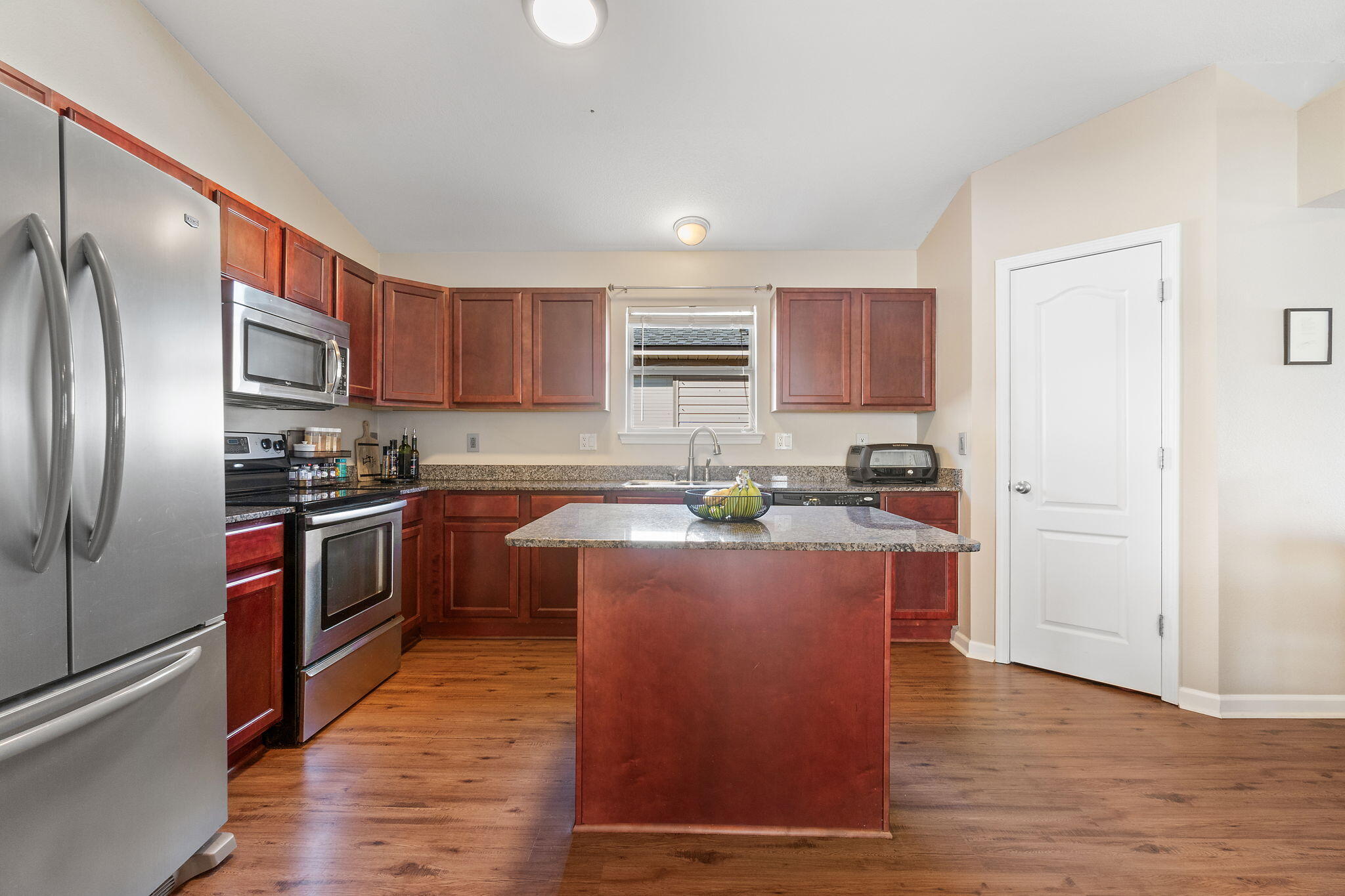 7964 Promise Creek Road Navarre, FL 32566 - Photo 6 of 43 a kitchen with stainless steel appliances granite countertop a refrigerator a stove top oven a sink and dishwasher with wooden floor