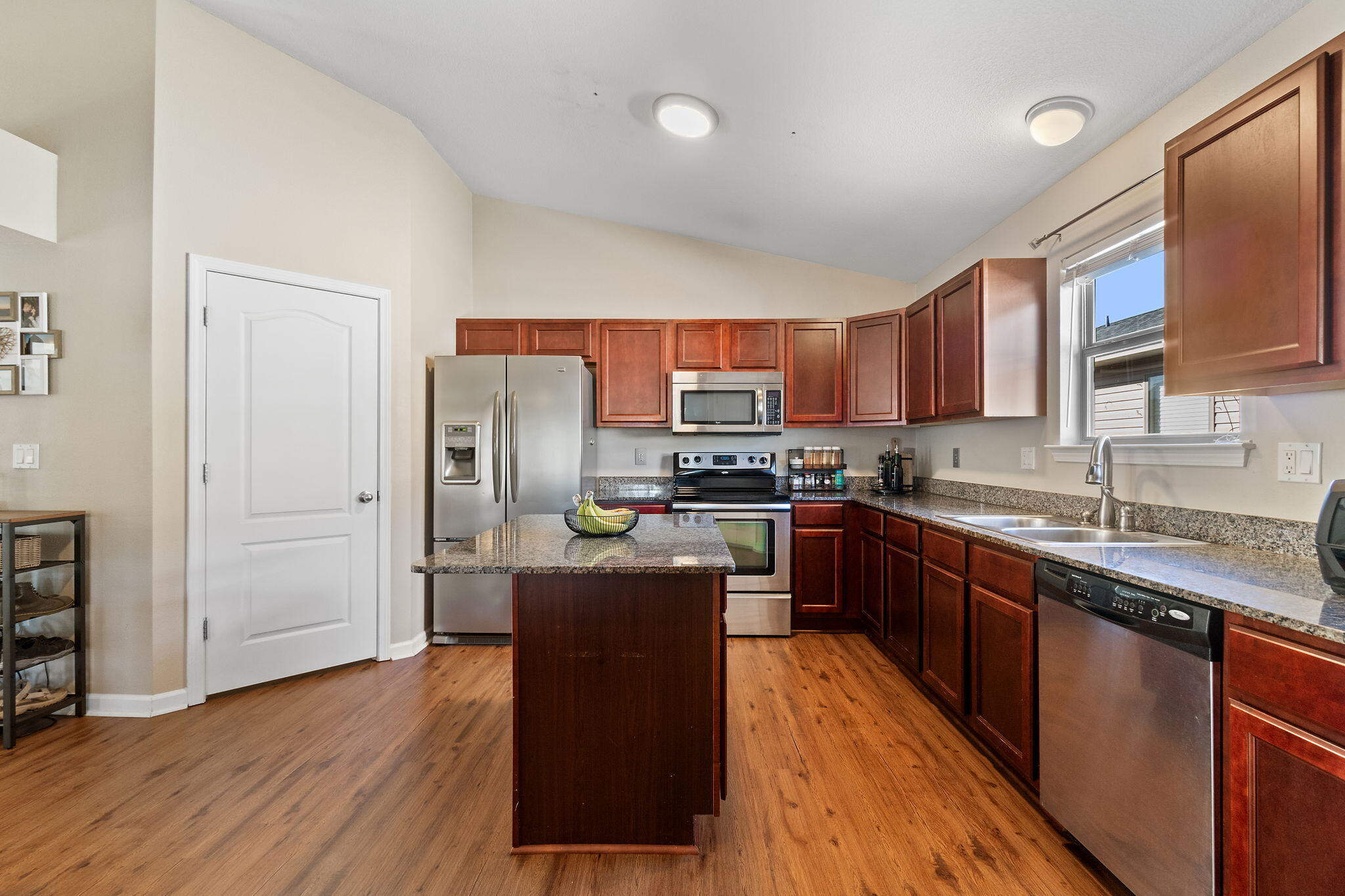 7964 Promise Creek Road Navarre, FL 32566 - Photo 8 of 43 a kitchen with stainless steel appliances granite countertop a refrigerator a sink dishwasher a stove top oven a refrigerator with wooden floor and cabinets