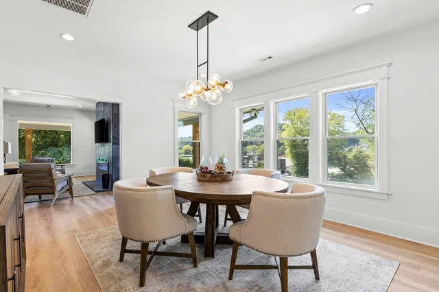 a dining room with furniture a chandelier and wooden floor