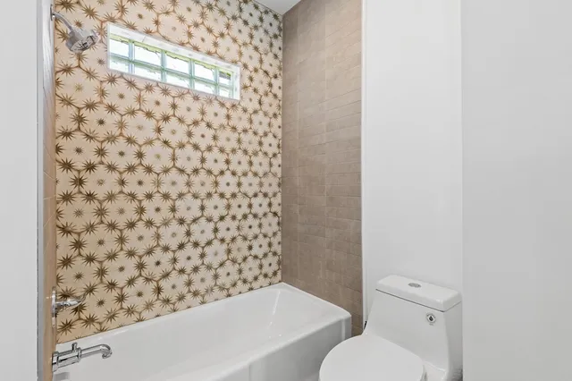 a bathroom with a toilet and a shower curtain