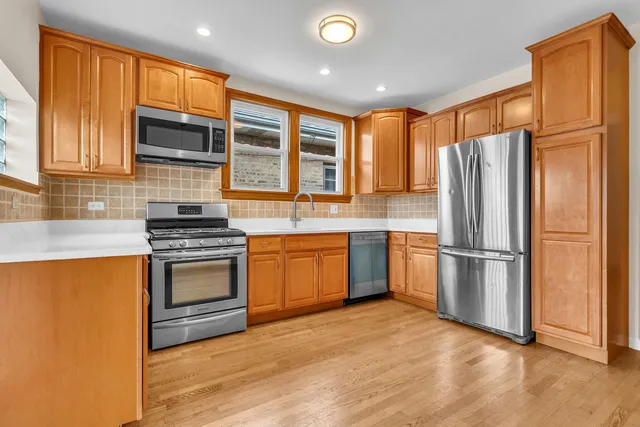 a kitchen with granite countertop a refrigerator stove top oven and sink