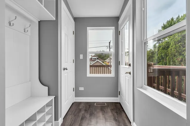 a view of a hallway with wooden floor and a living room