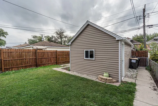 a view of a small house next to a yard