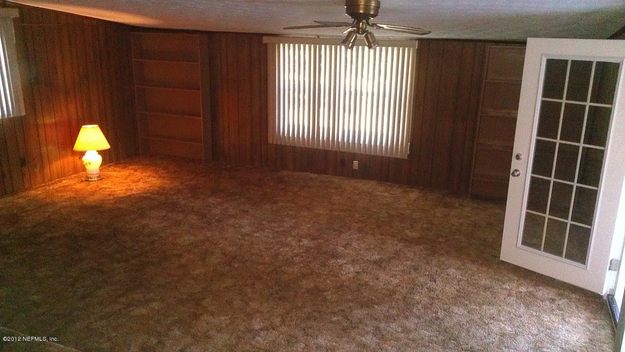 10587 Villanova Road Jacksonville, FL 32218 - Photo 7 of 13 an empty room with windows and chandelier fan