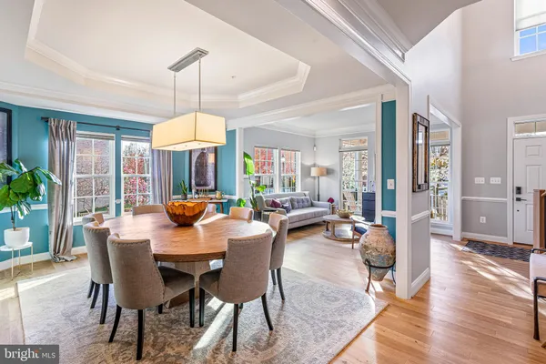 a view of a dining room with furniture a chandelier and wooden floor