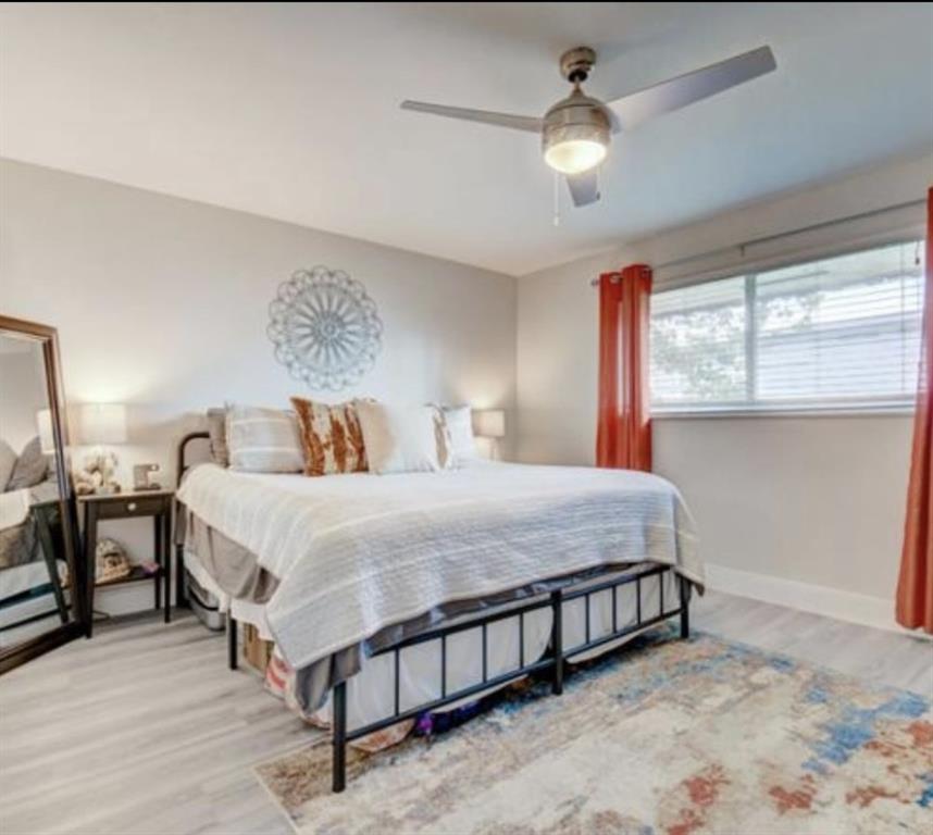 55 Southeast 14th Street, Unit 207 Boca Raton, FL 33432 - Photo 4 of 9 a bedroom with a bed and a chandelier