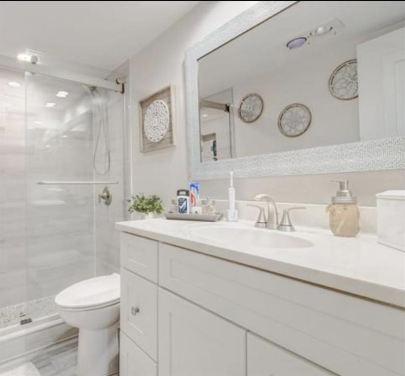 55 Southeast 14th Street, Unit 207 Boca Raton, FL 33432 - Photo 6 of 9 a bathroom with a granite countertop sink mirror vanity and toilet