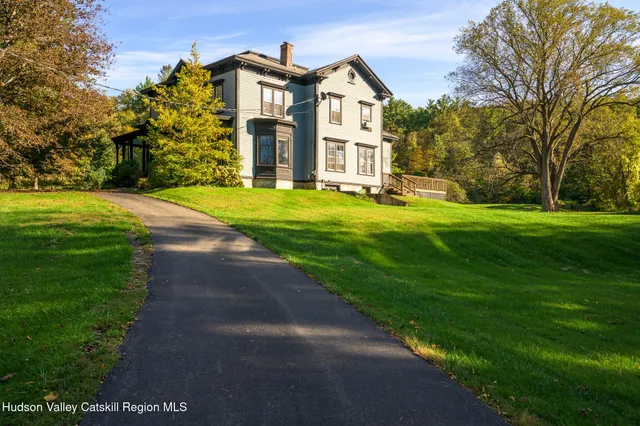 a front view of a house with yard and green space