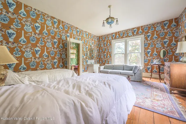 a spacious bedroom with a bed couch and a window
