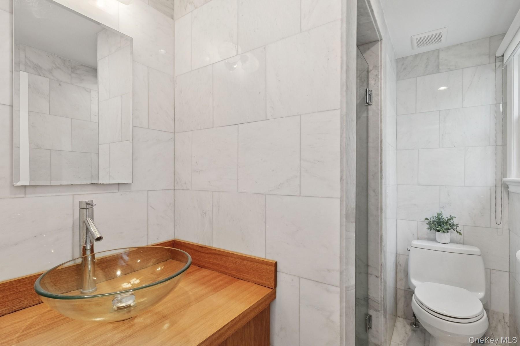 80 Towd Point Road Southampton, NY 11968 - Photo 18 of 30 a bathroom with a sink a toilet and a mirror