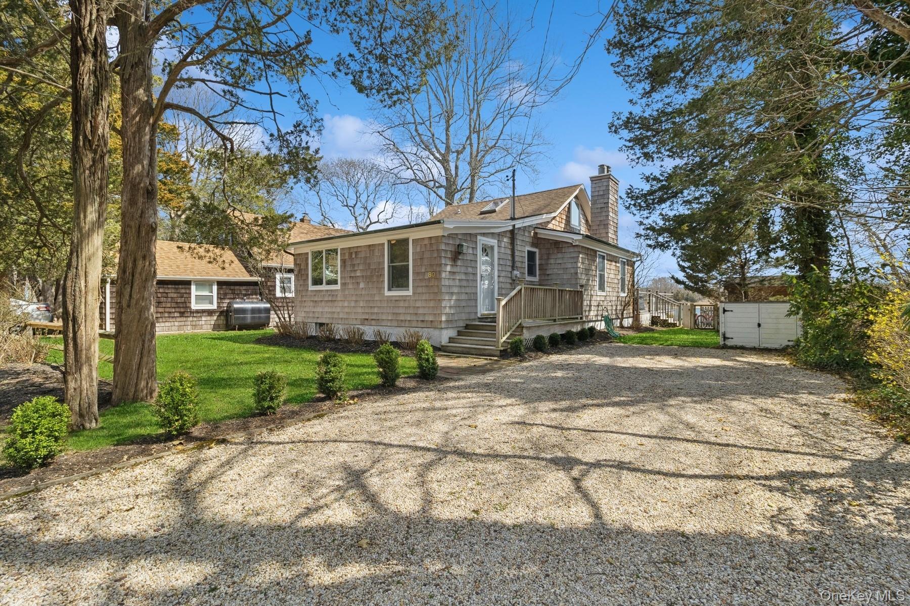 80 Towd Point Road Southampton, NY 11968 - Photo 2 of 30 a view of a yard in front of a brick house with large windows