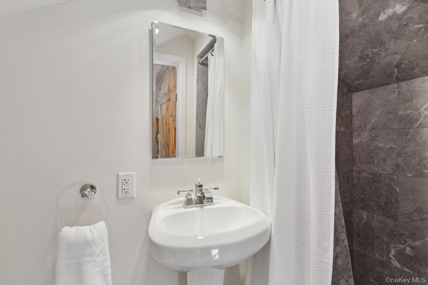 80 Towd Point Road Southampton, NY 11968 - Photo 22 of 30 a bathroom with a sink and a mirror