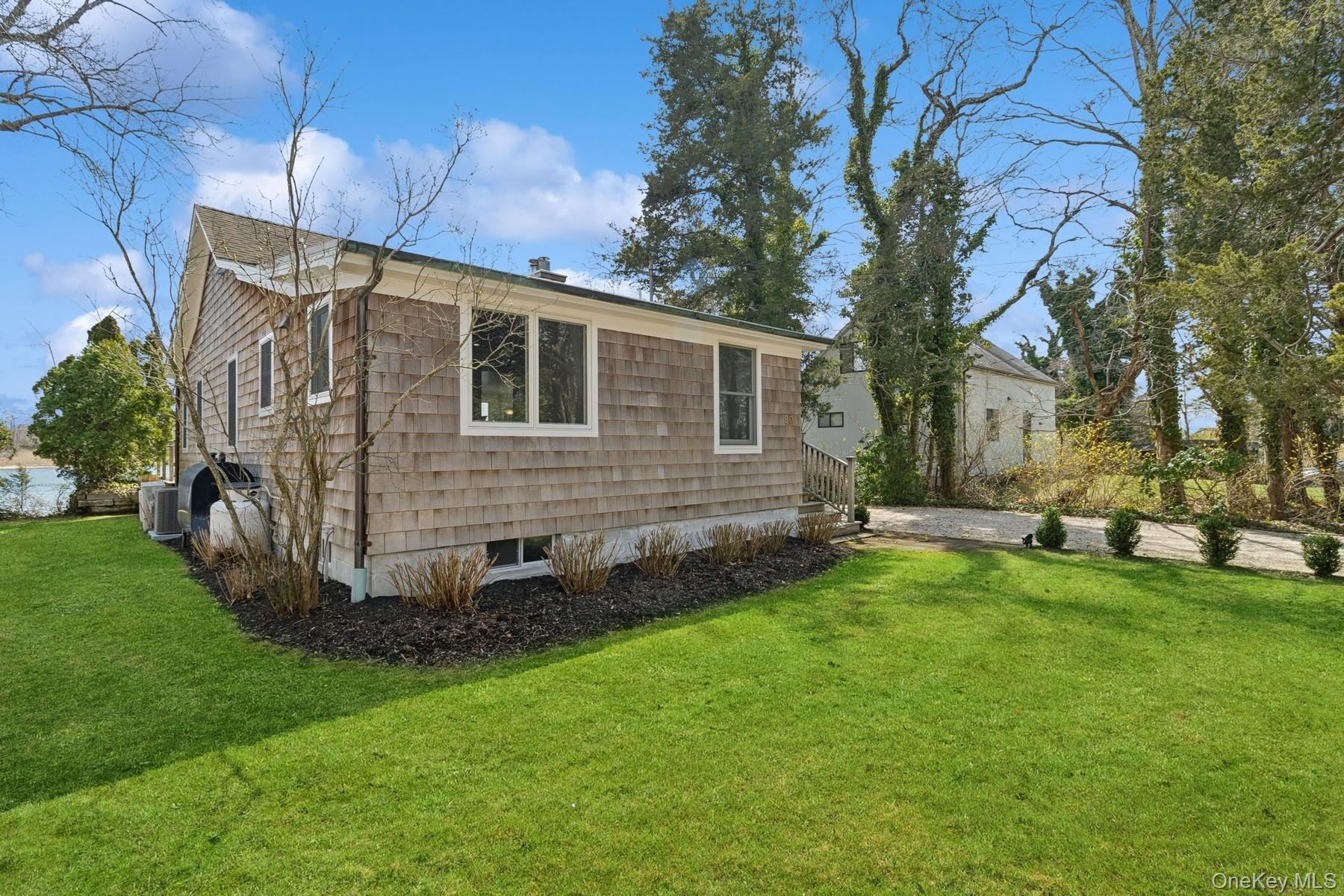 80 Towd Point Road Southampton, NY 11968 - Photo 4 of 30 a backyard of a house with table and chairs