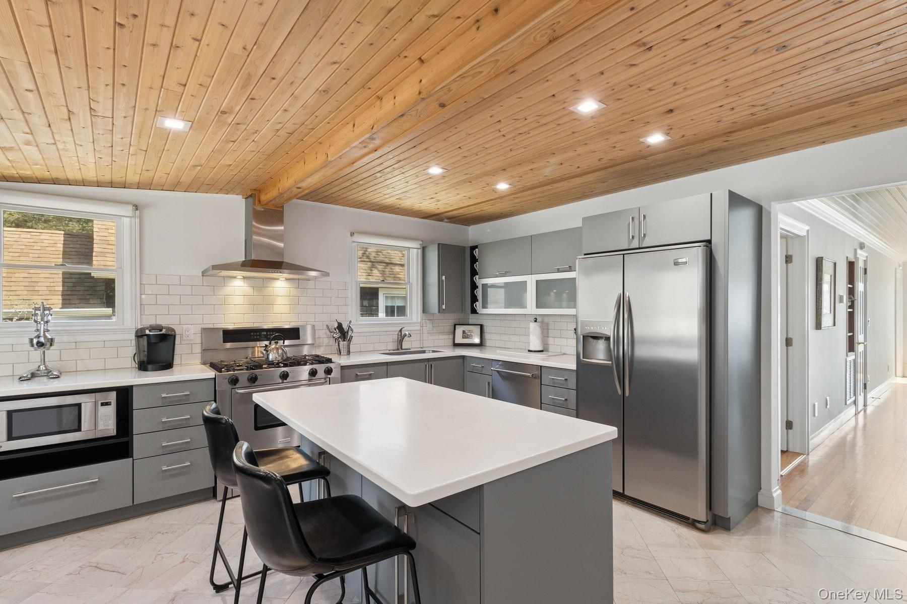 80 Towd Point Road Southampton, NY 11968 - Photo 5 of 30 a kitchen with stainless steel appliances a table chairs refrigerator and cabinets