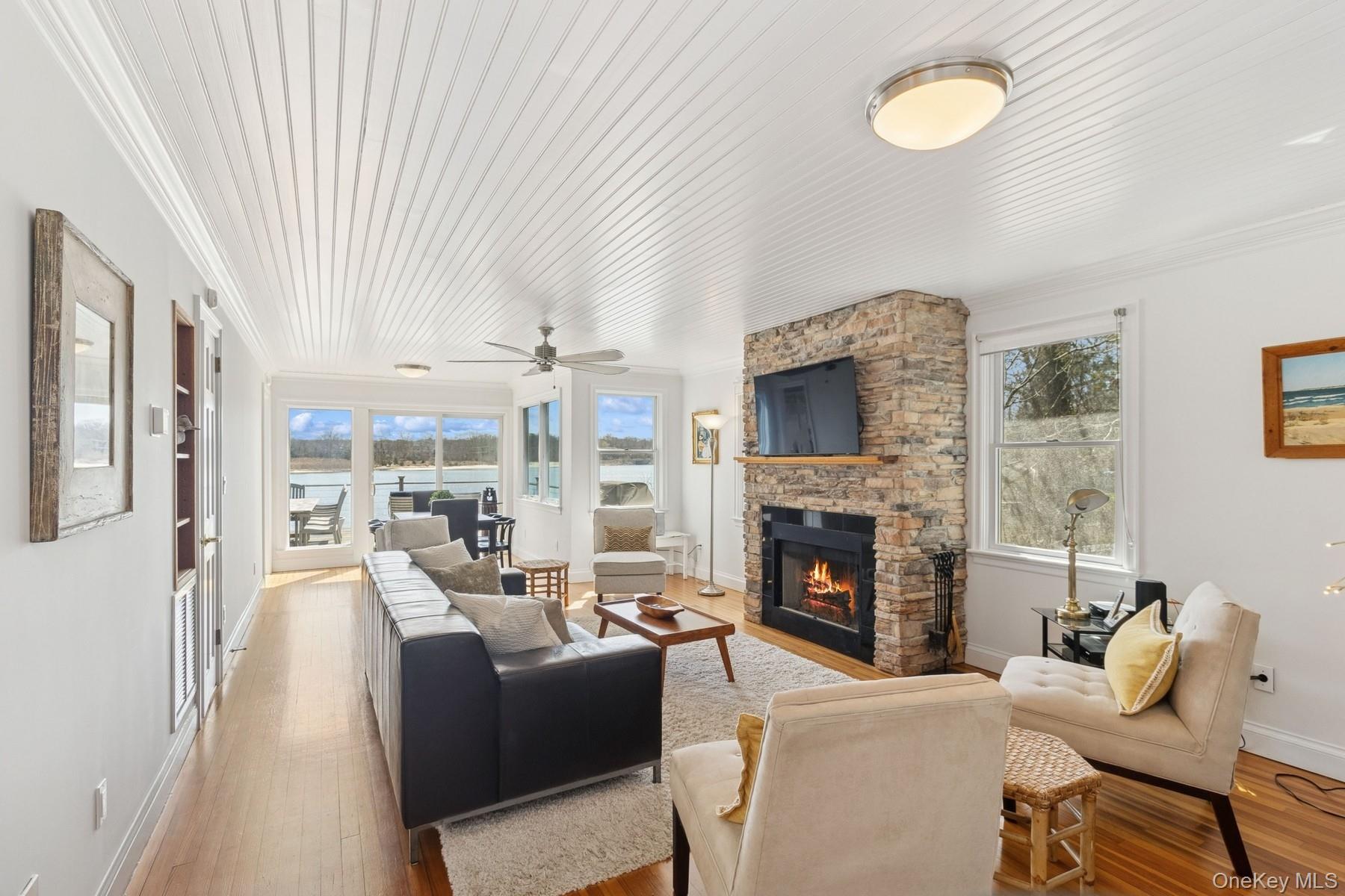 80 Towd Point Road Southampton, NY 11968 - Photo 9 of 30 a living room with furniture a fireplace and a large window