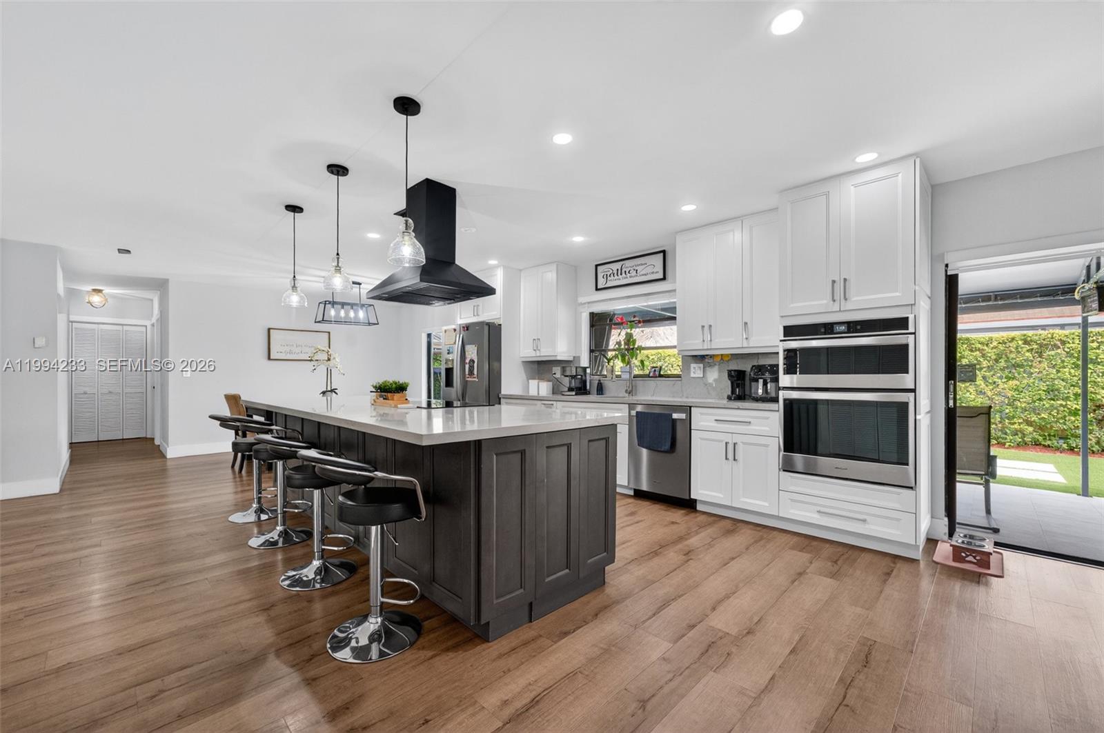 2385 Southwest 131st Place Miami, FL 33175 - Photo 1 of 39 a kitchen with stainless steel appliances a dining table chairs stove and wooden floor