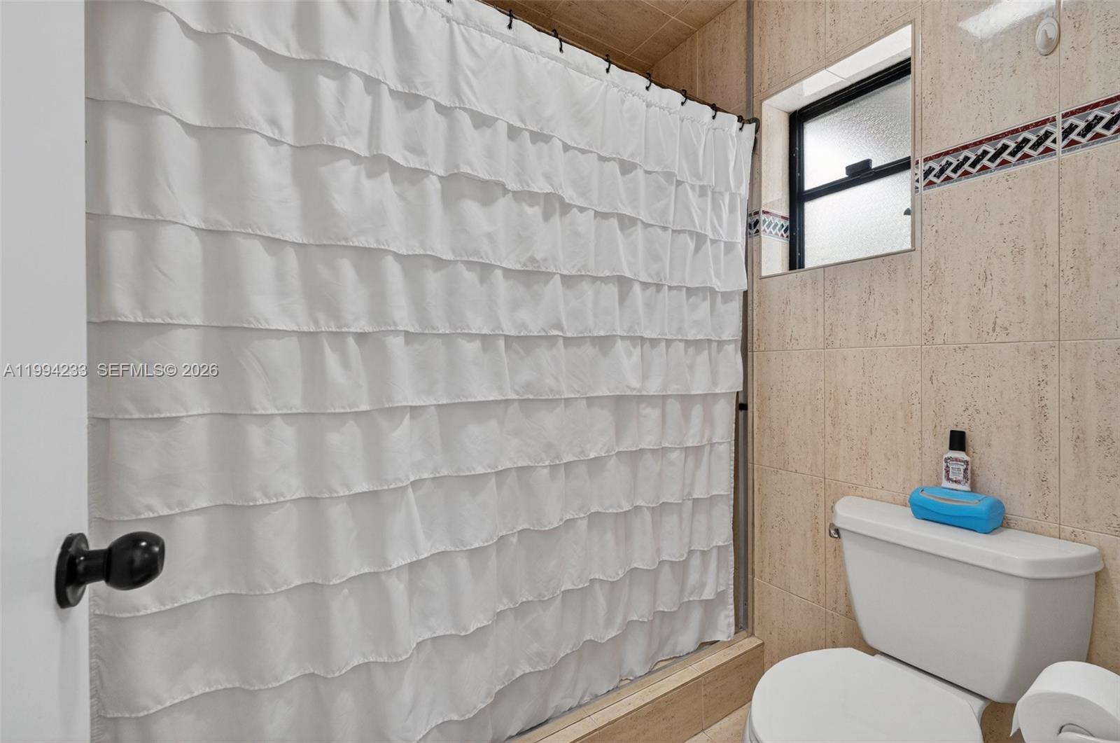 2385 Southwest 131st Place Miami, FL 33175 - Photo 11 of 39 a bathroom with a toilet and a shower curtain
