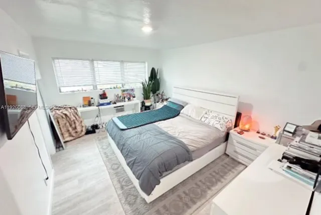 a bedroom with a bed couch and window