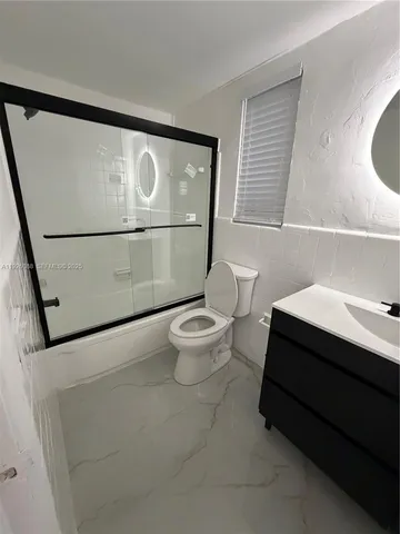 a bathroom with a toilet a sink and a mirror