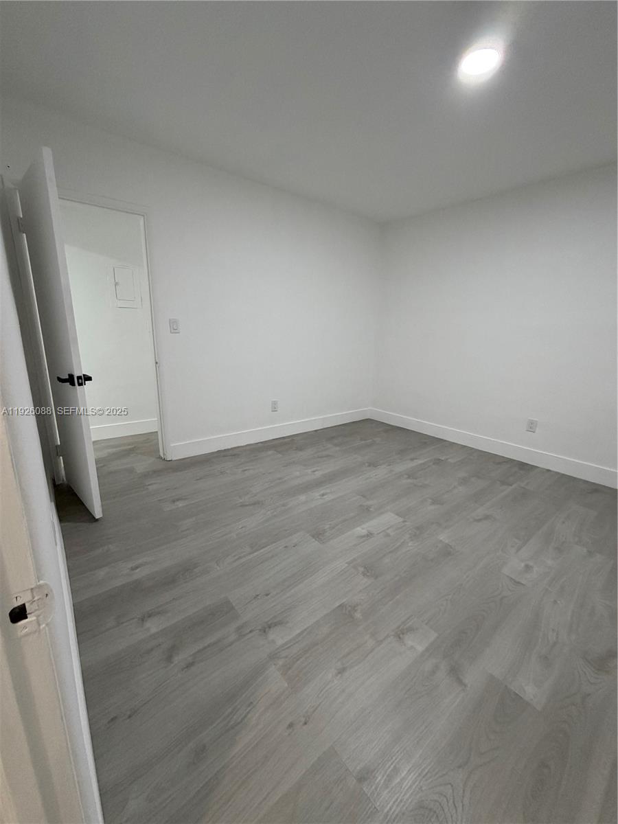 324 Surfside Boulevard, Unit 7 Surfside, FL 33154 - Photo 6 of 14 an empty room with wooden floor and bathroom