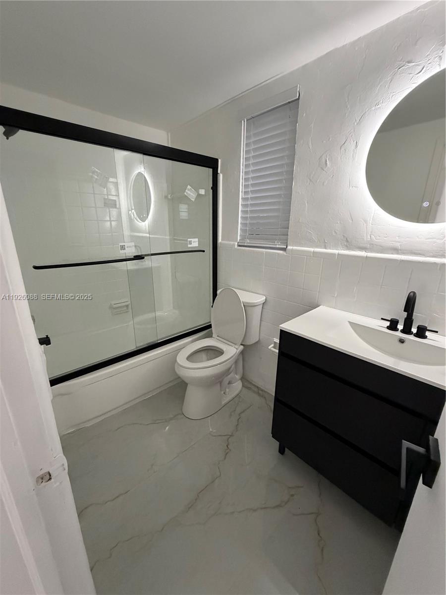 324 Surfside Boulevard, Unit 7 Surfside, FL 33154 - Photo 10 of 14 a bathroom with a sink mirror and toilet