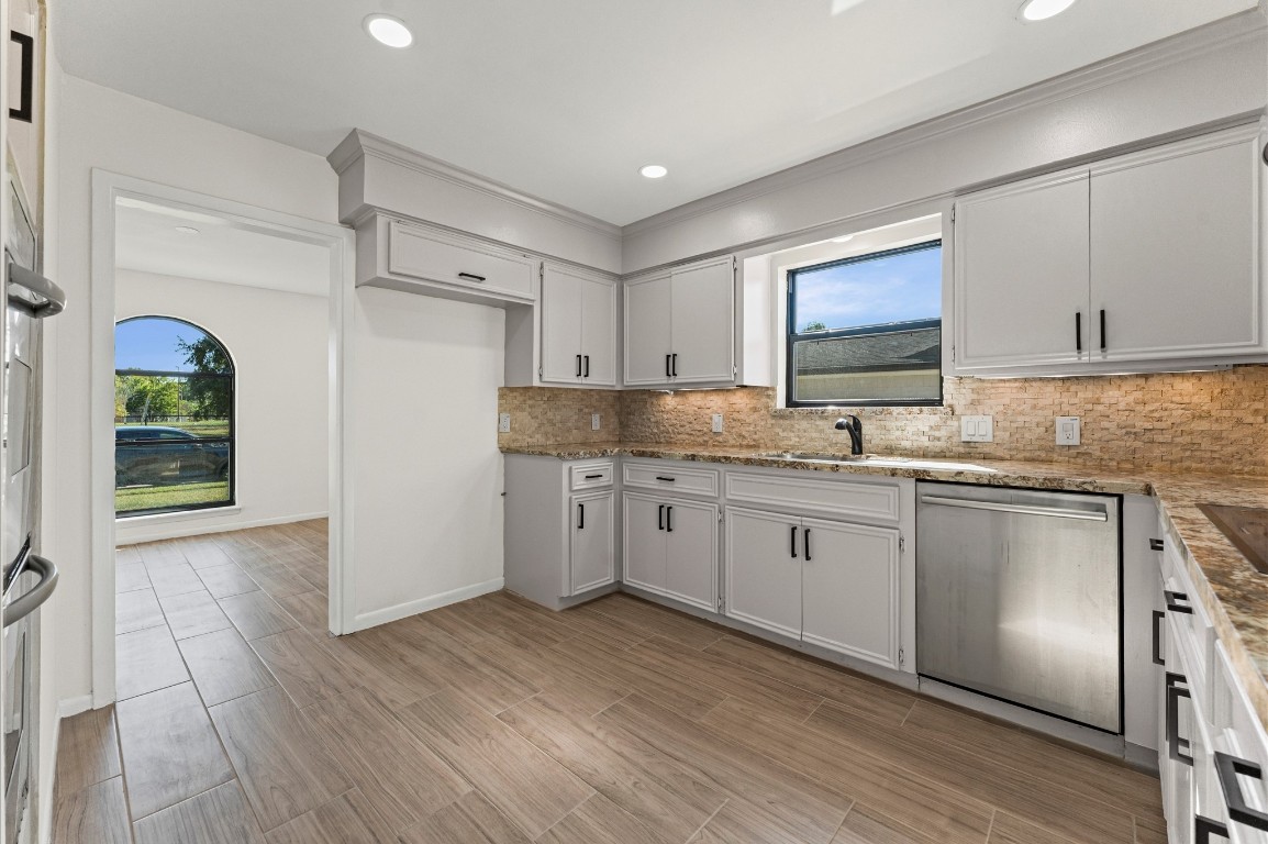 5634 Jason Street Houston, TX 77096 - Photo 12 of 25 a kitchen with granite countertop a sink cabinets stainless steel appliances and a window