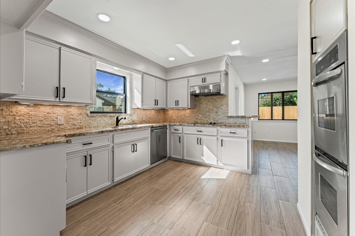5634 Jason Street Houston, TX 77096 - Photo 13 of 25 a kitchen with a white cabinets sink and stainless steel appliances