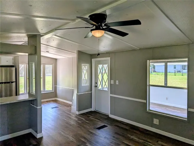 a view of an empty room with window and wooden floor