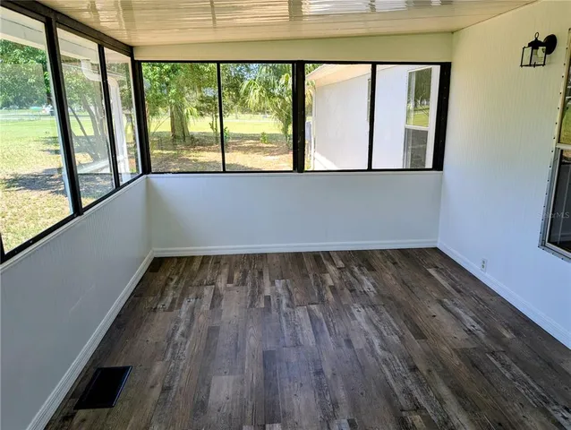a view of a room with wooden floor and windows