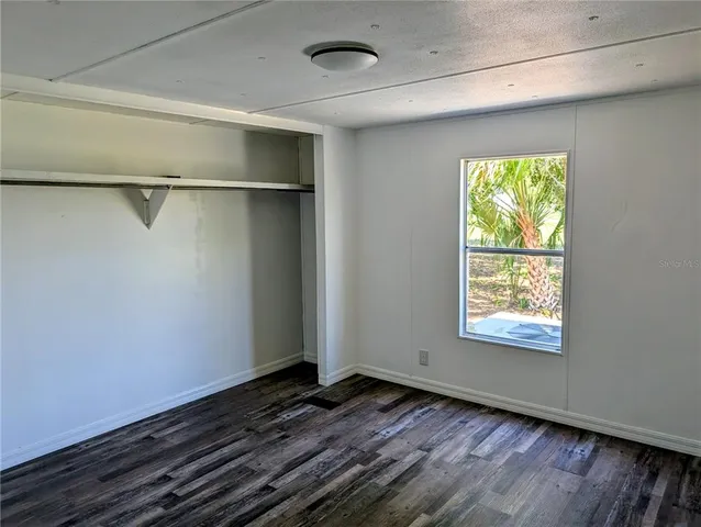 a view of a room with wooden floor and a window