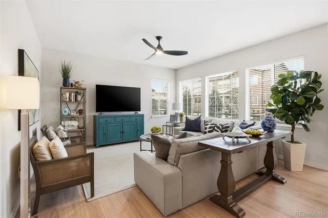 a living room with furniture a flat screen tv and a large window