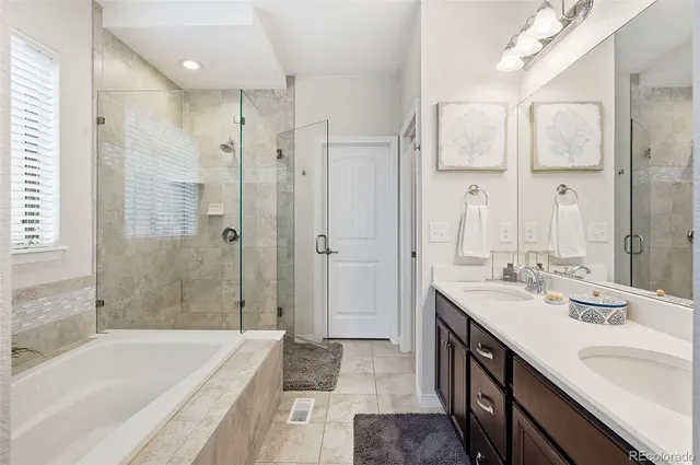 a bathroom with a tub sink shower and a mirror