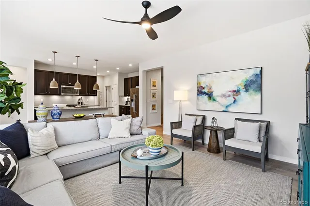 a living room with furniture and a view of kitchen