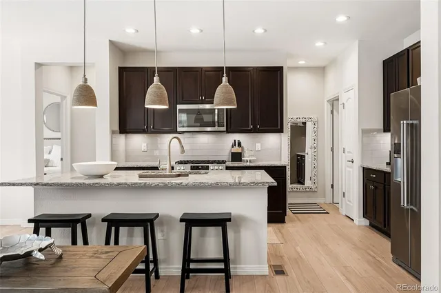 a kitchen with stainless steel appliances granite countertop a stove a sink and a refrigerator