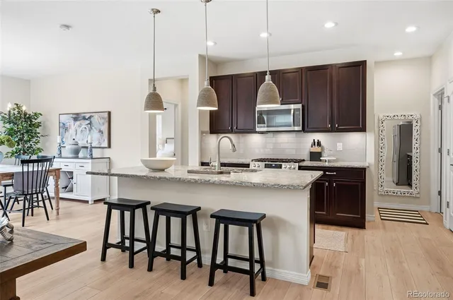 a kitchen with stainless steel appliances granite countertop a stove a refrigerator a kitchen island a sink and a refrigerator