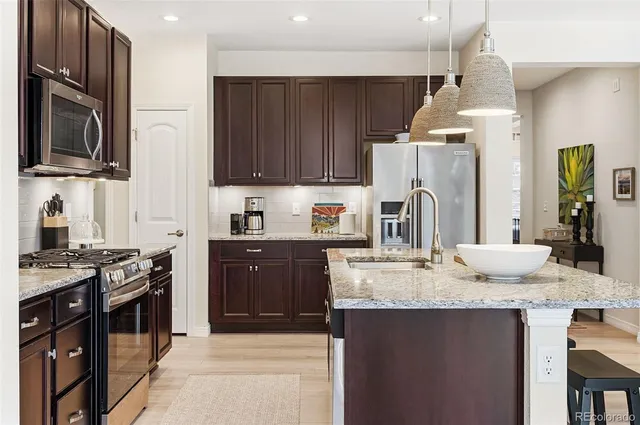 a kitchen with granite countertop a sink stove and refrigerator