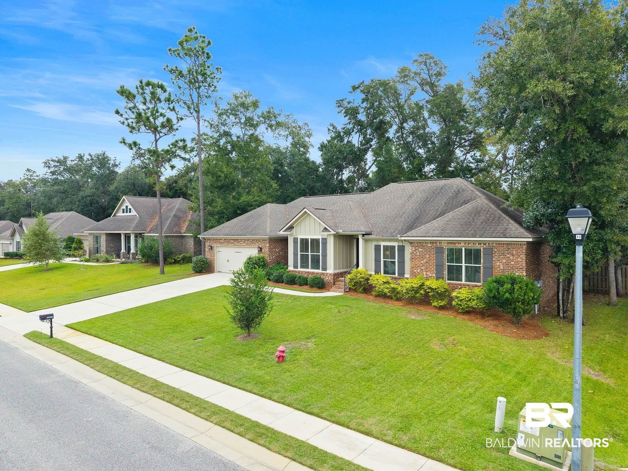 19740 Bunker Loop Fairhope, AL 36532 - Photo 2 of 33 Single story home with board and batten siding, driveway, a front lawn, an attached garage, and brick siding